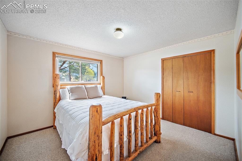 Image 13 of 40: Carpeted bedroom with a closet and a textured ceiling