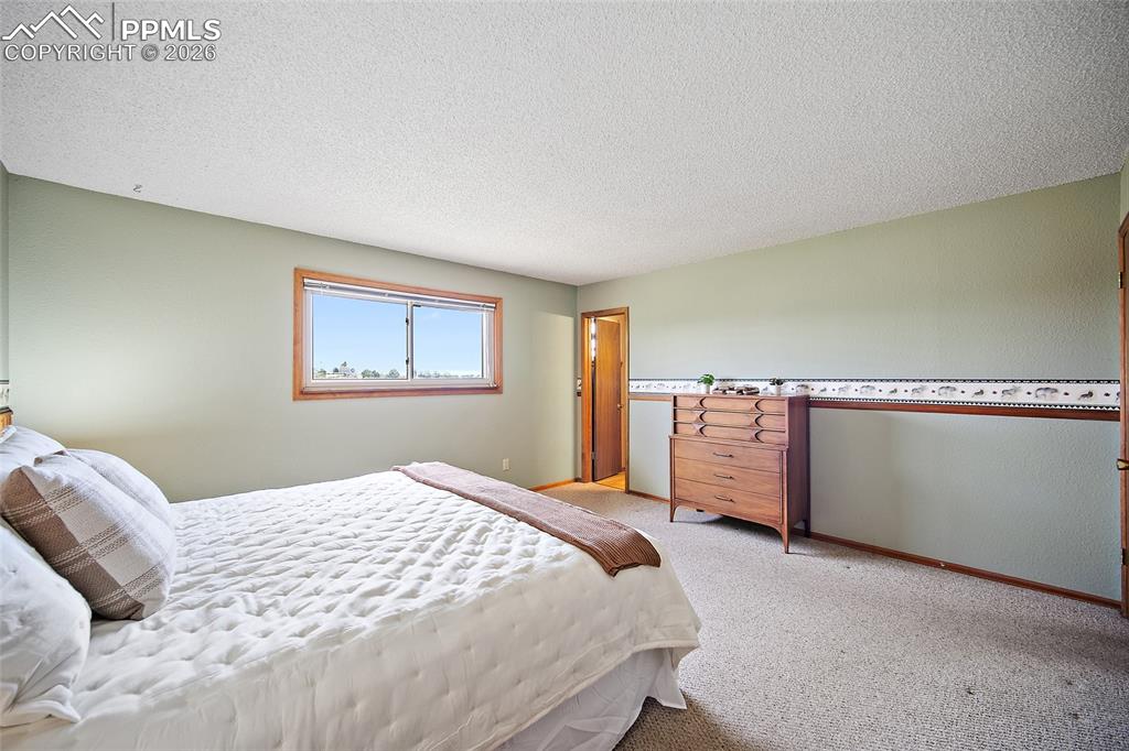 Image 16 of 40: Bedroom with a textured ceiling and light carpet
