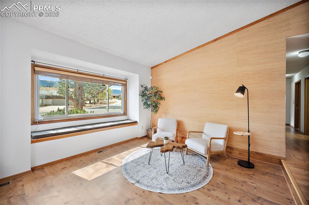Image 5 of 40: Living area with light wood-style flooring and an accent wall