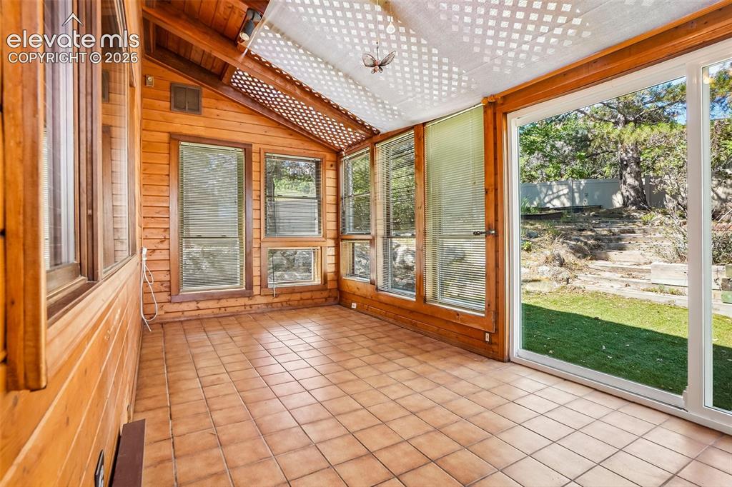 Image 16 of 48: Off the large family room is a sun room with access to backyard and rear de