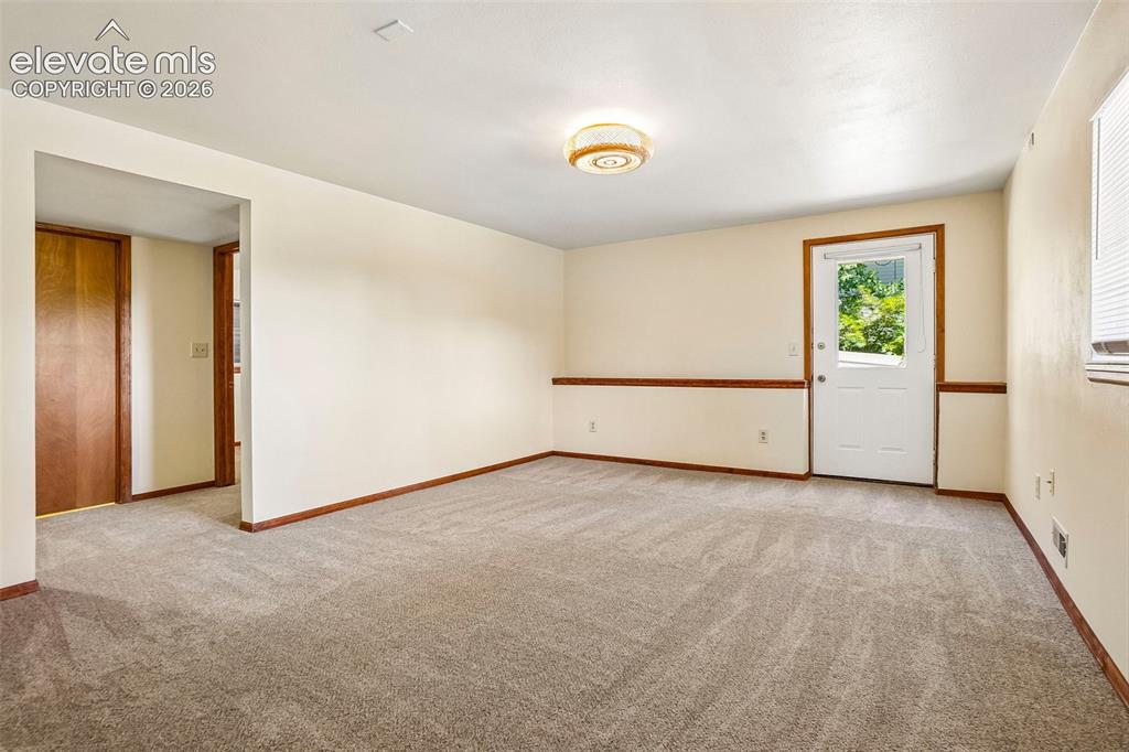 Image 20 of 48: There is another large living space in the basement, with its own outdoor a