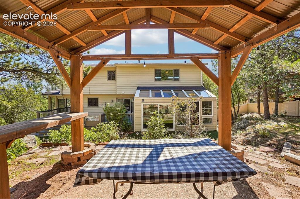 Image 39 of 48: View of the house from the backyard pergola that sits atop a hill.