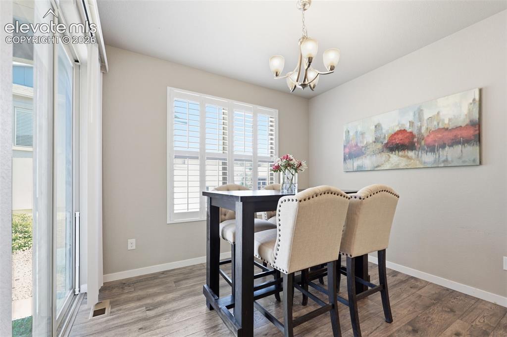 Image 10 of 43: Sliding glass door, light brown luxury vinyl plank flooring, window with pl