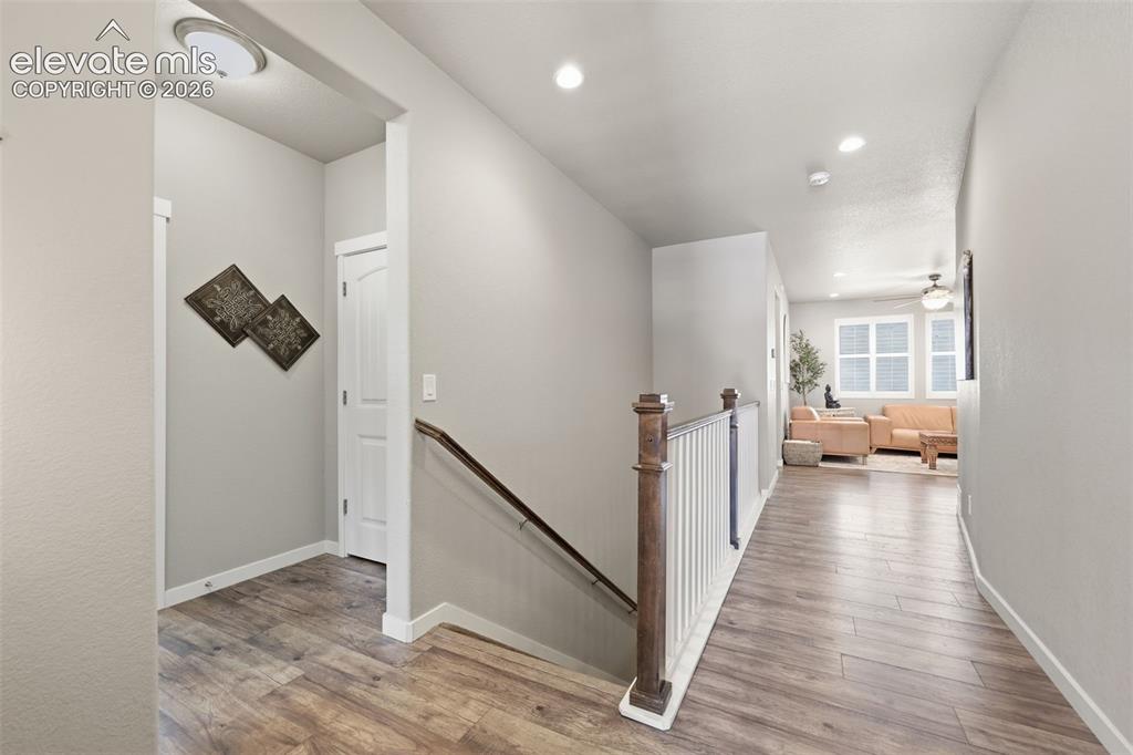 Image 15 of 43: Light brown luxury vinyl plank flooring, white interior doors, and a wood b