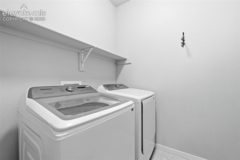 Image 16 of 43: Laundry area featuring a wall-mounted shelf, light-toned walls, and a multi
