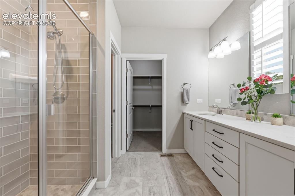 Image 19 of 43: Spacious bathroom featuring a glass-enclosed shower with subway tile, a dua