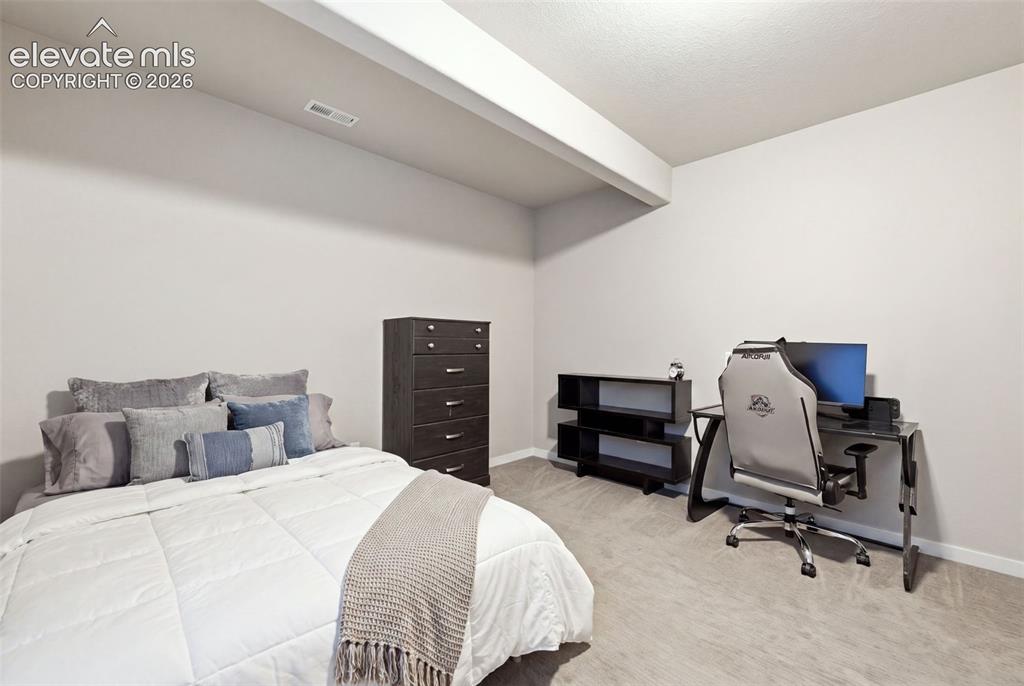Image 30 of 43: Neutral wall color with recessed lighting, complemented by a textured ceili