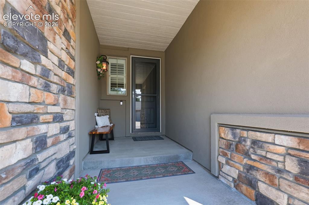 Image 37 of 43: Stone veneer and stucco exterior with a covered entry.