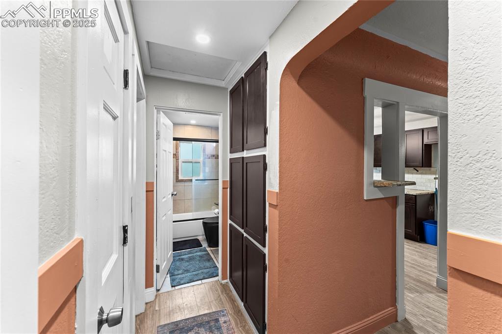 Image 10 of 26: Hallway with a textured wall and light wood-type flooring