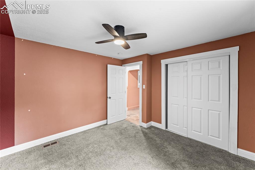 Image 14 of 26: Unfurnished bedroom featuring carpet, a ceiling fan, and a closet
