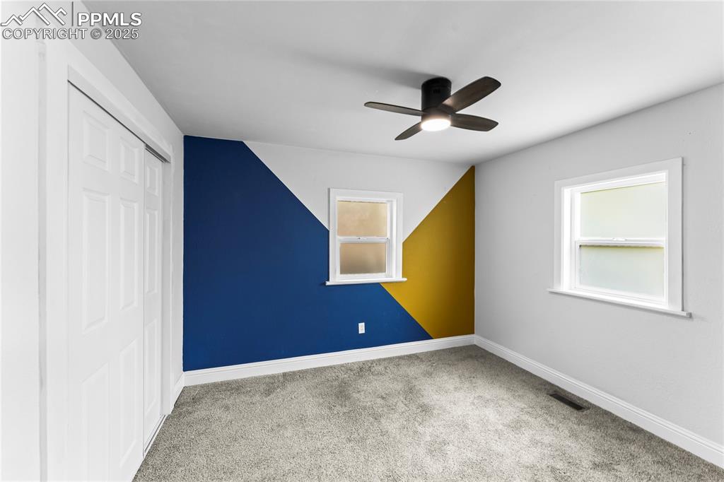 Image 15 of 26: Unfurnished bedroom with carpet flooring, a closet, and a ceiling fan