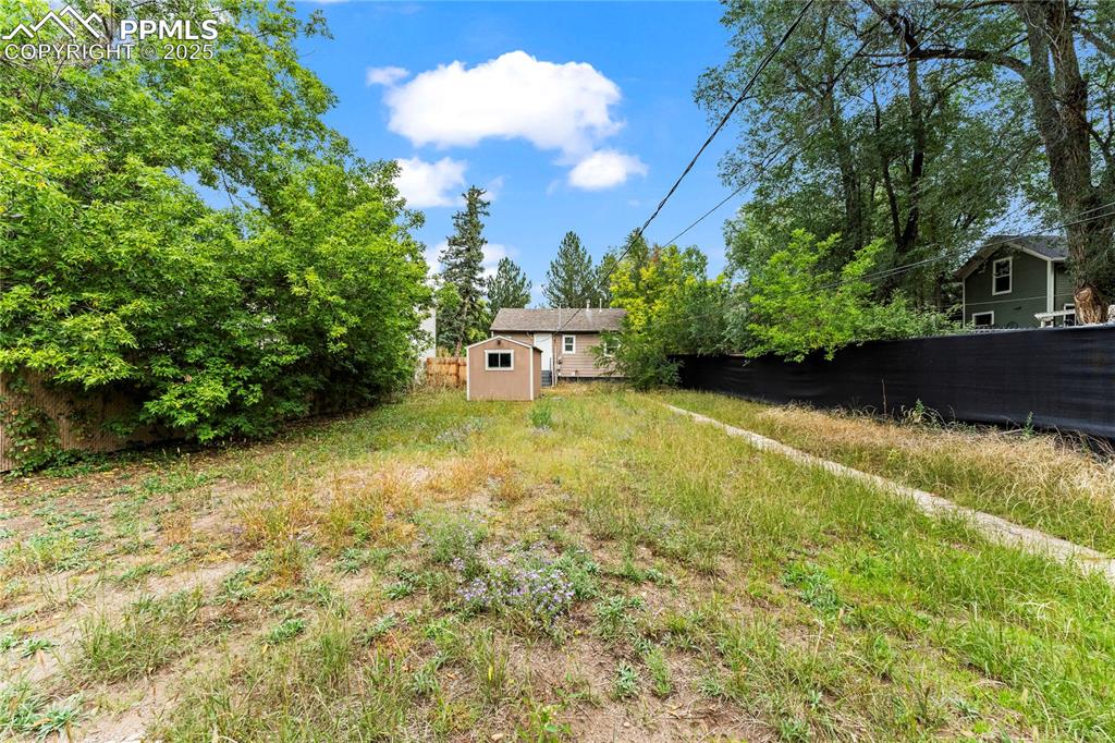 Image 19 of 26: Fenced backyard with a storage shed