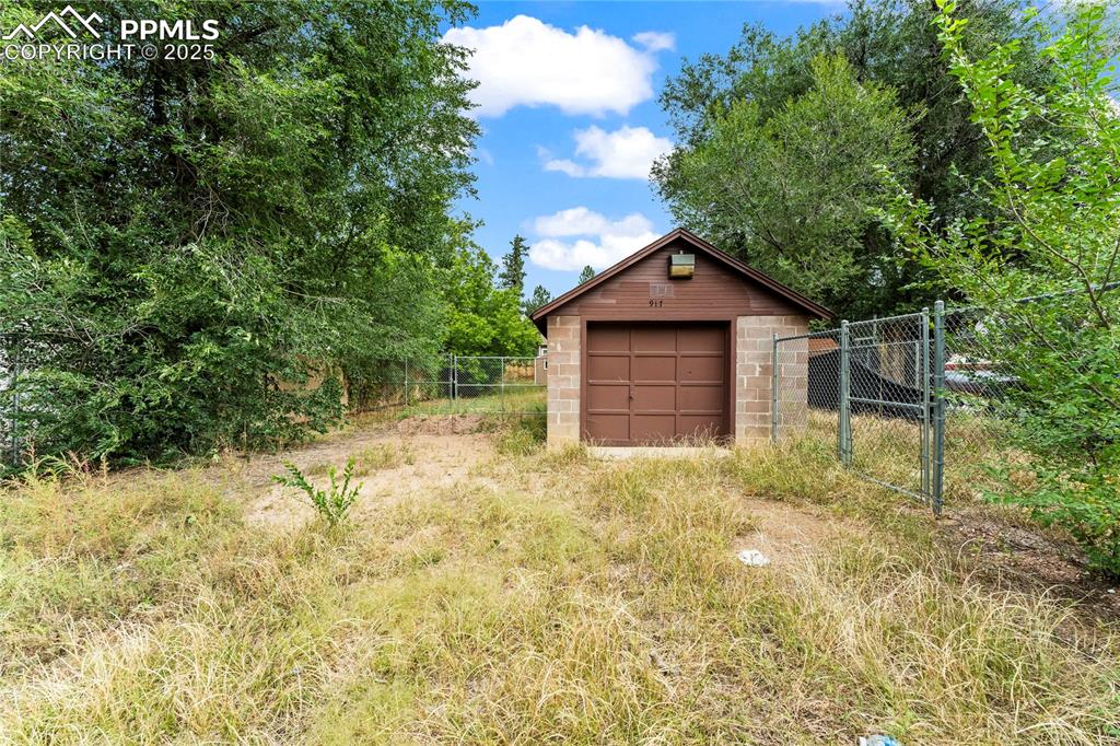 Image 21 of 26: Detached garage with view of scattered trees