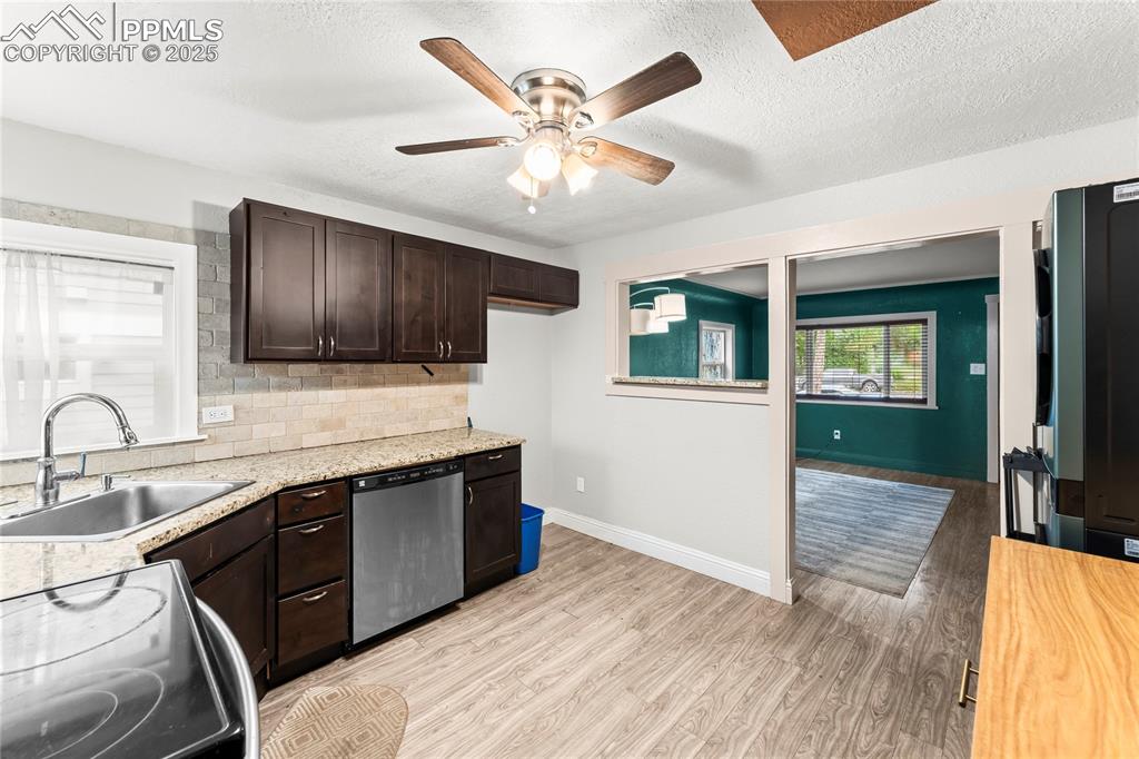 Image 8 of 26: Kitchen with dark brown cabinets, light wood finished floors, stainless ste