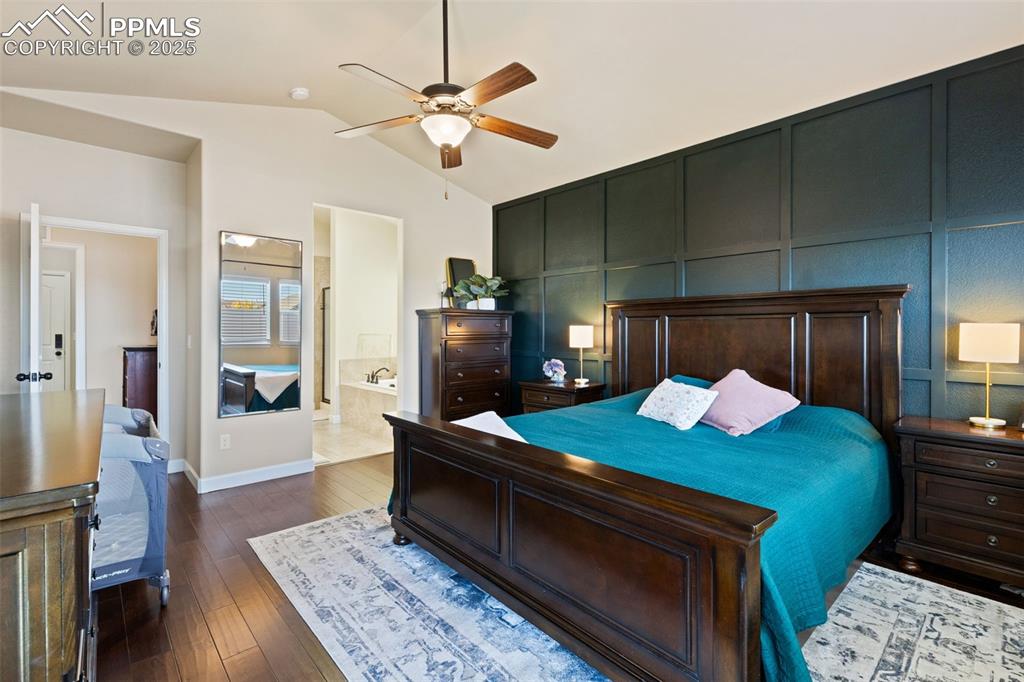 Image 17 of 31: Bedroom featuring a decorative wall, dark wood-style floors, a ceiling fan,