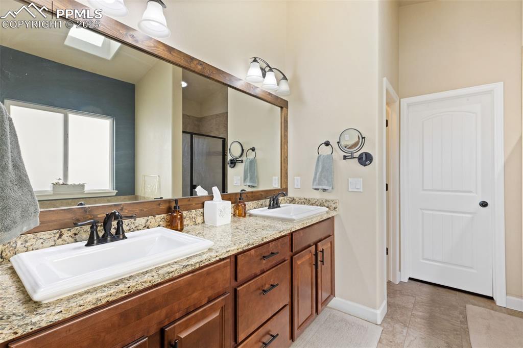 Image 19 of 31: Full bathroom with a stall shower, double vanity, and light tile patterned