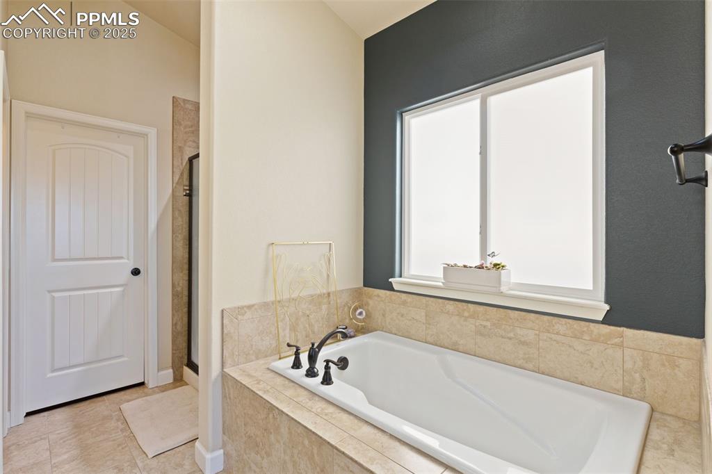 Image 20 of 31: Full bath with a bath, a shower stall, and light tile patterned flooring