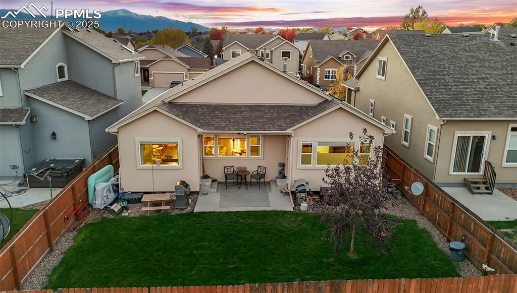 Image 4 of 31: Back of house with stucco siding, a patio area, a shingled roof, and a fenc