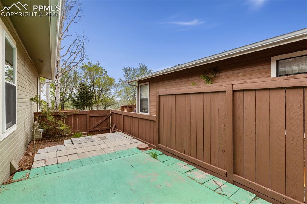 Image 16 of 27: The property features an outdoor patio area with a partial concrete and par