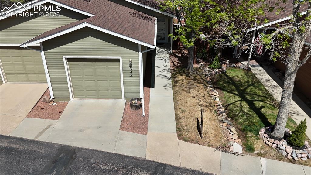 Image 17 of 20: The property features a concrete driveway and walkway, leading to a garage 