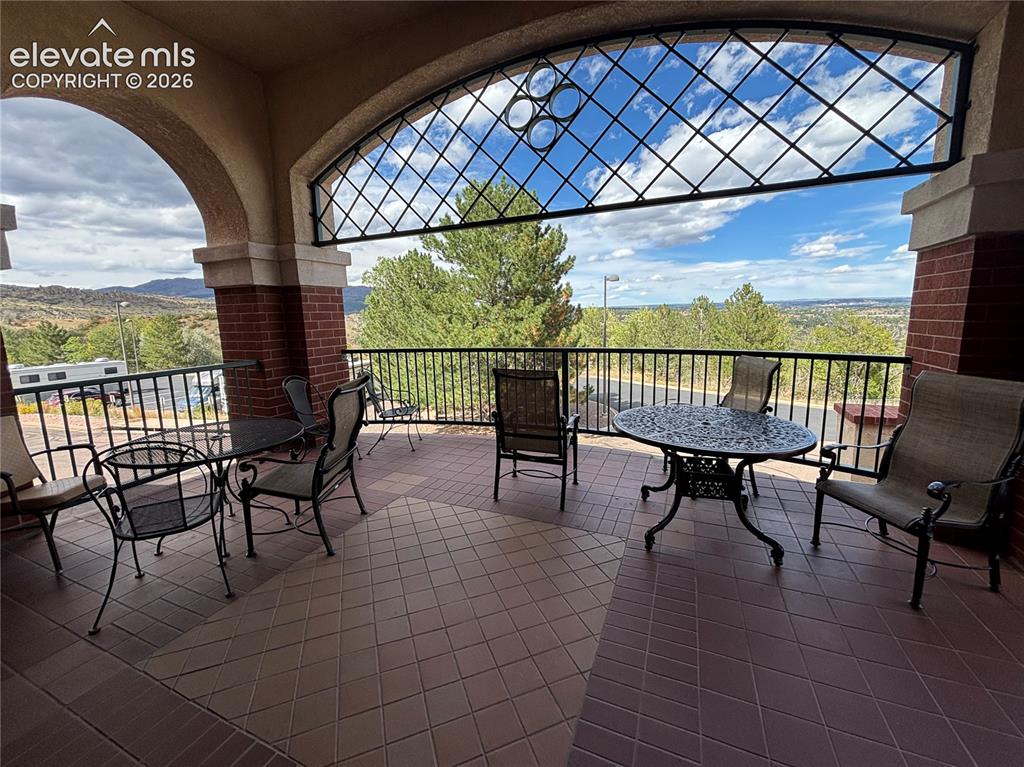Image 24 of 27: Covered patio featuring an arched entryway and brick columns