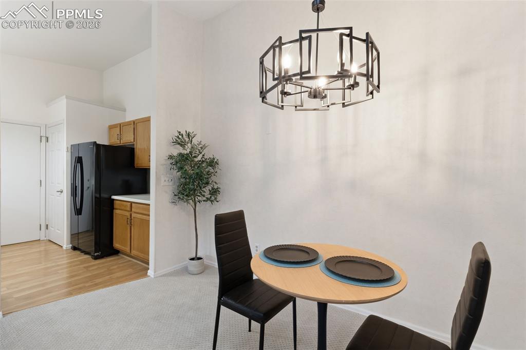 Image 5 of 27: The property features a kitchen area with wooden cabinetry and a black refr