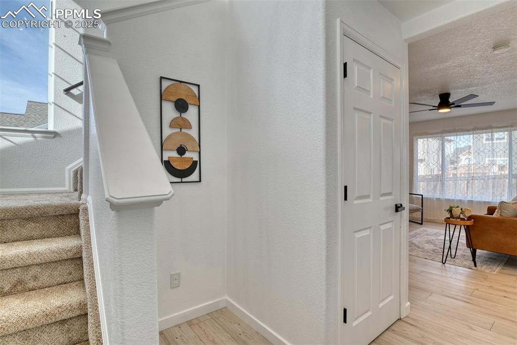 Image 15 of 45: Stairs featuring wood finished floors and ceiling fan