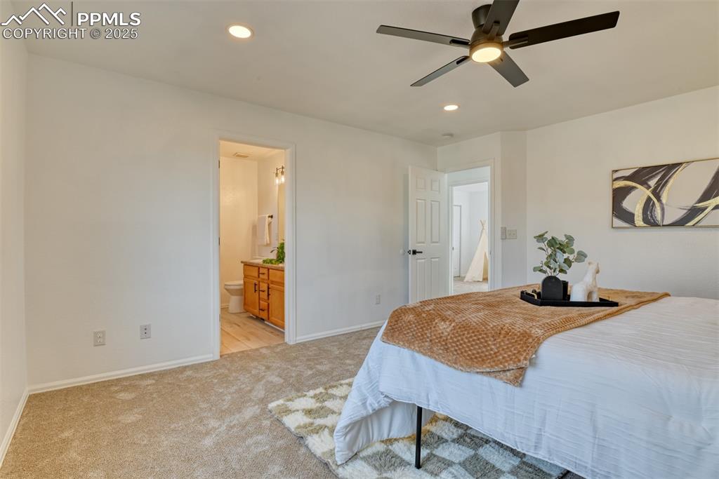Image 21 of 45: Bedroom featuring recessed lighting, light carpet, a ceiling fan, and ensui