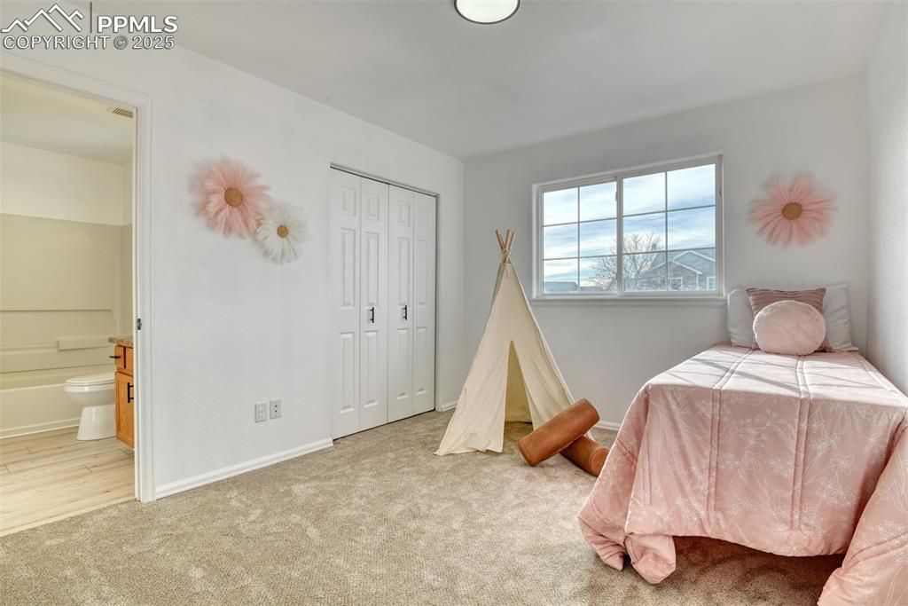 Image 26 of 45: Bedroom featuring light colored carpet, a closet, and ensuite bathroom