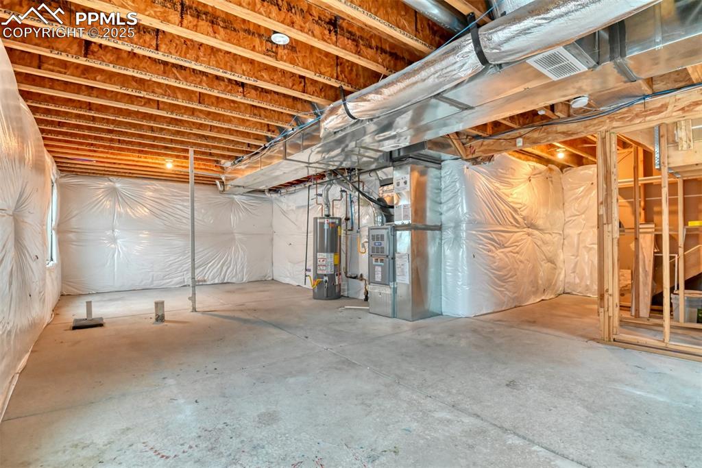 Image 39 of 45: Unfinished basement featuring gas water heater and heating unit
