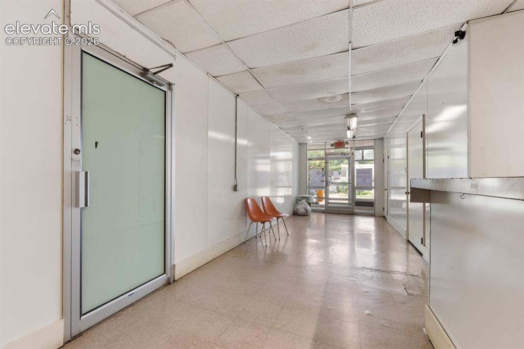 Image 17 of 50: Green door is access to another part of the building that has unused office