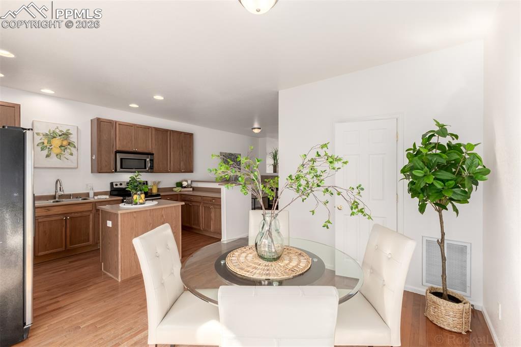 Image 14 of 33: Dining space with hardwod flooring and slider to back patio
