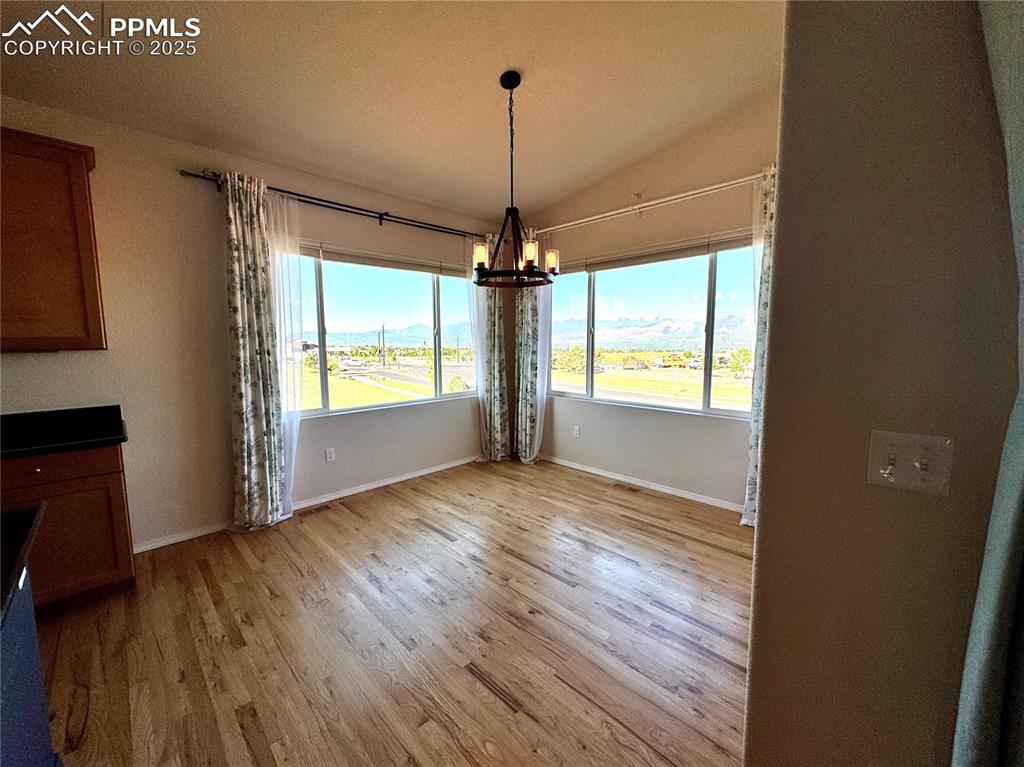 Image 10 of 36: Unfurnished dining area featuring a chandelier, light wood-type flooring, a