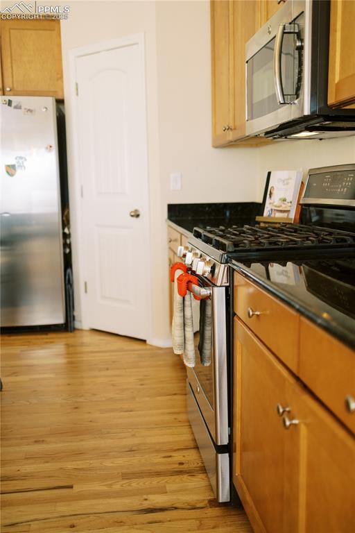 Image 14 of 36: Kitchen featuring appliances with stainless steel finishes, light wood-styl