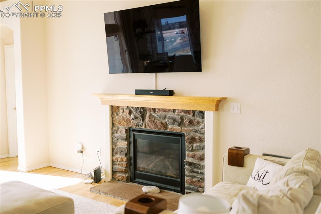 Image 16 of 36: Detailed view of wood finished floors, a fireplace, and arched walkways