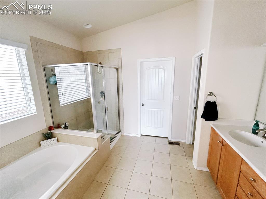 Image 21 of 36: Bathroom with a shower stall, tile patterned flooring, vanity, and a garden