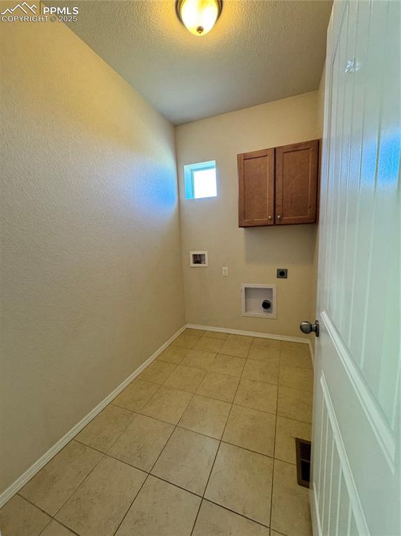 Image 25 of 36: Laundry area featuring hookup for an electric dryer, cabinet space, light t