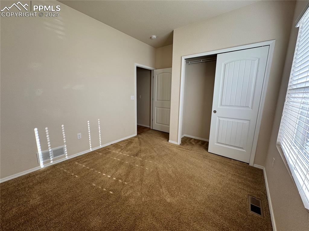Image 26 of 36: Unfurnished bedroom with carpet and a closet