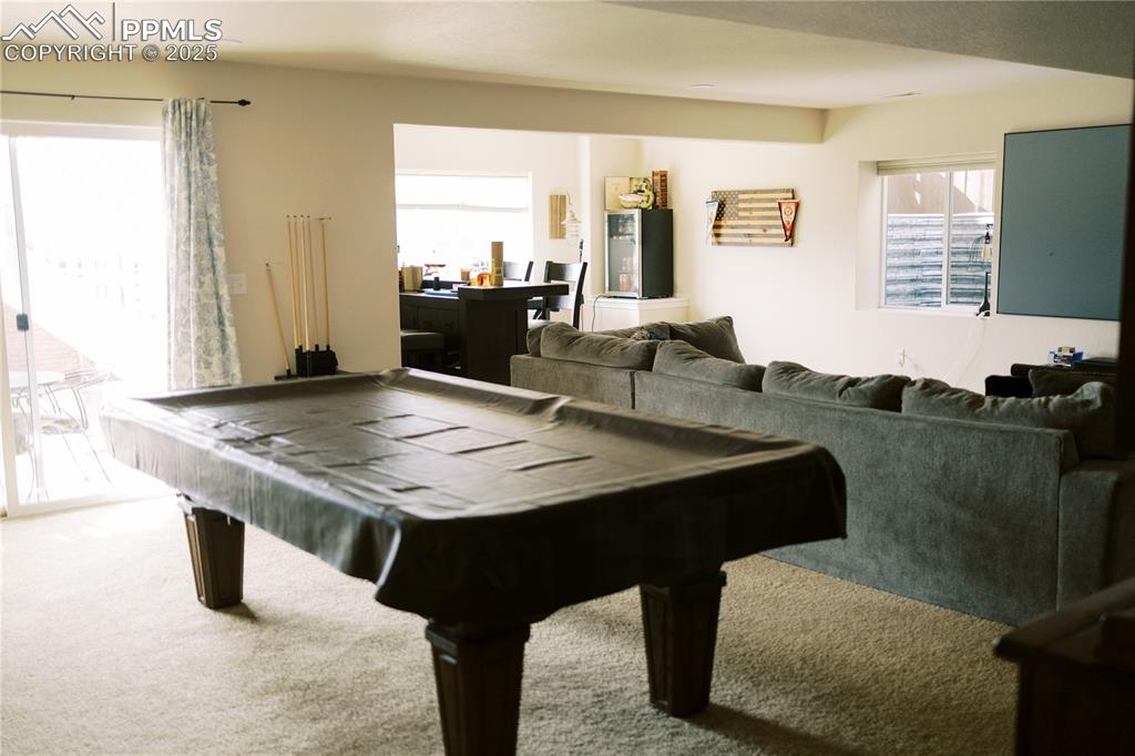 Image 27 of 36: Recreation room with carpet floors and pool table