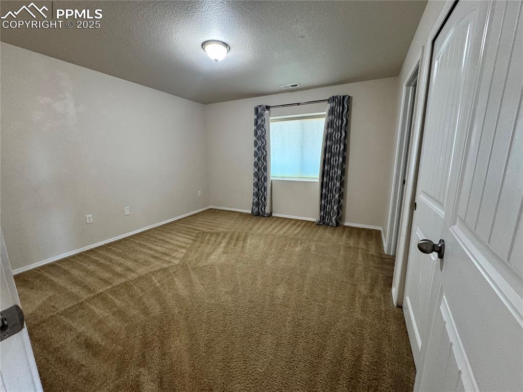 Image 29 of 36: Unfurnished room with carpet and a textured ceiling