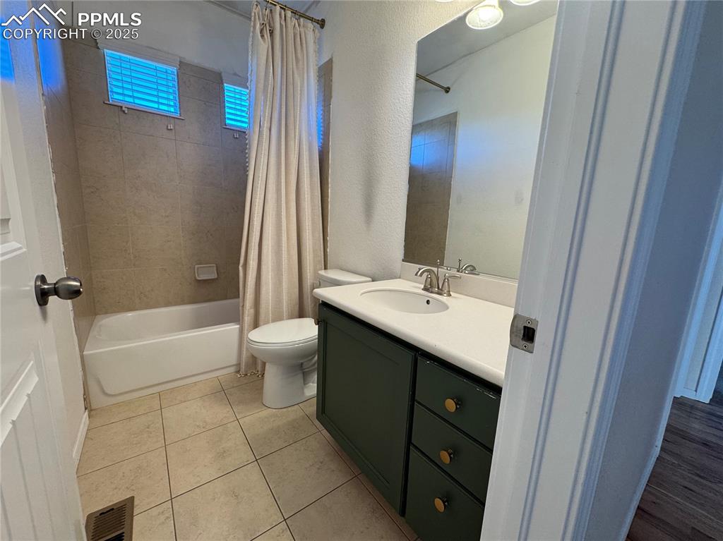 Image 32 of 36: Bathroom featuring shower / bath combo, vanity, and tile patterned floors