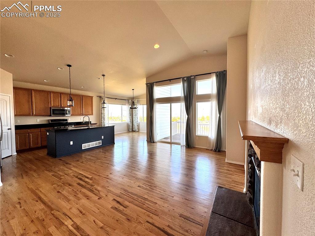 Image 8 of 36: Kitchen featuring dark countertops, open floor plan, wood finished floors, 