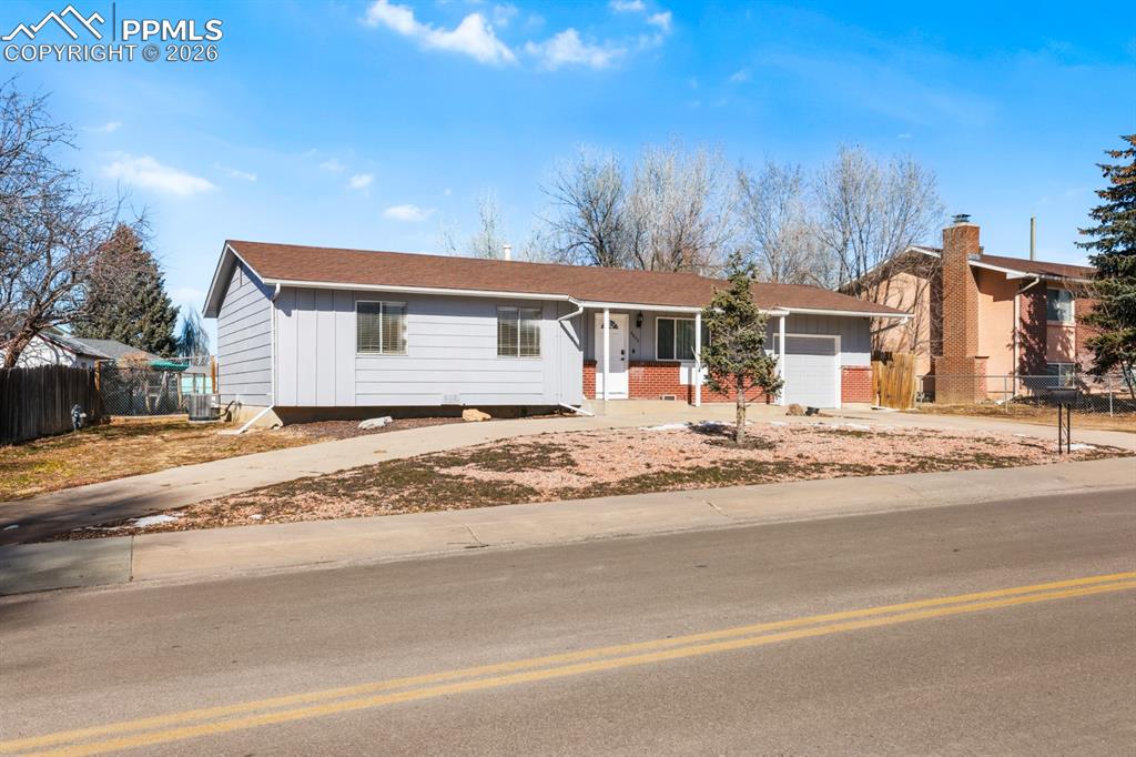 Image 11 of 37: Ranch-style home featuring driveway, covered porch, an attached garage, boa