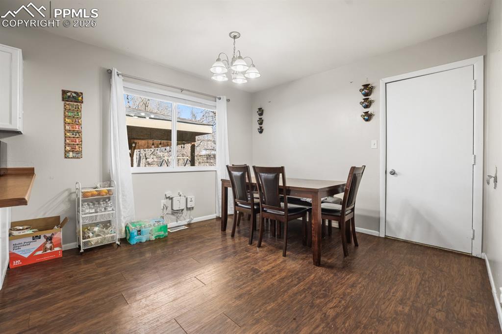 Image 21 of 37: Dining area featuring dark wood-style flooring and hanging lights