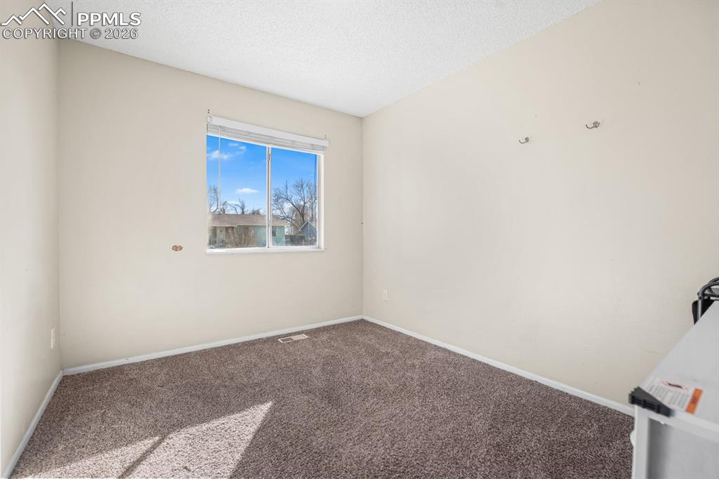 Image 23 of 37: Carpeted spare room with baseboards and a textured ceiling