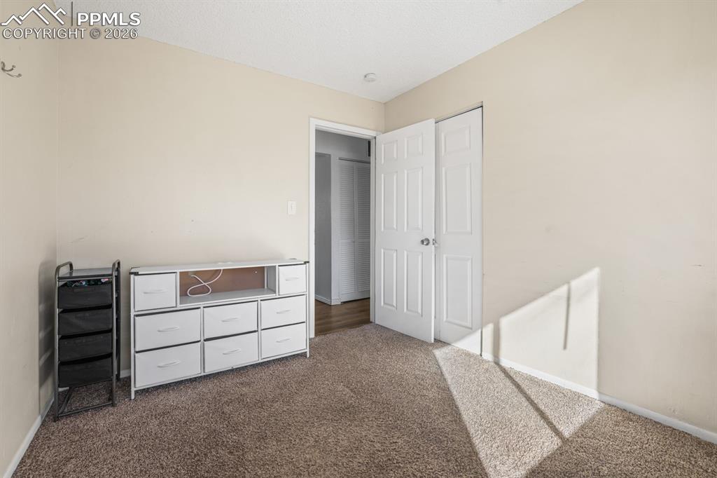 Image 24 of 37: Unfurnished bedroom featuring baseboards and dark colored carpet