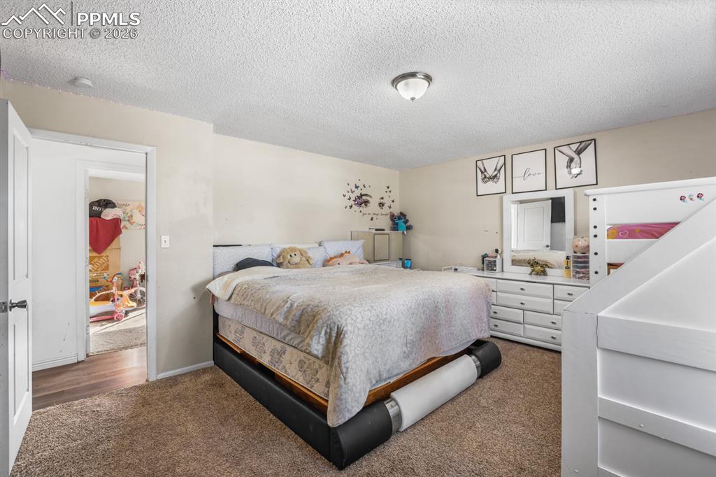 Image 28 of 37: Bedroom with a textured ceiling and carpet floors