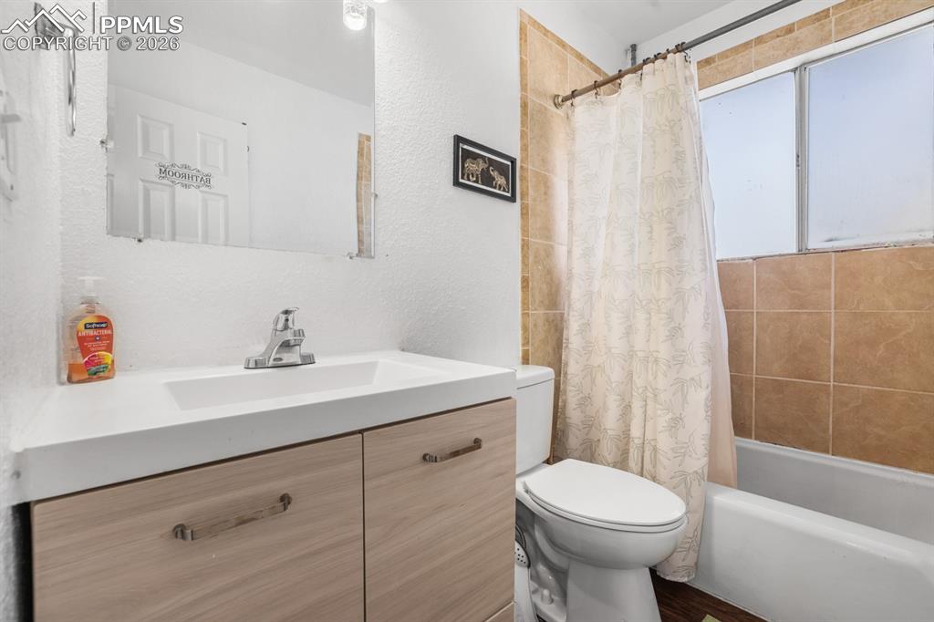 Image 29 of 37: Bathroom with vanity, shower / bath combination with curtain, and a texture