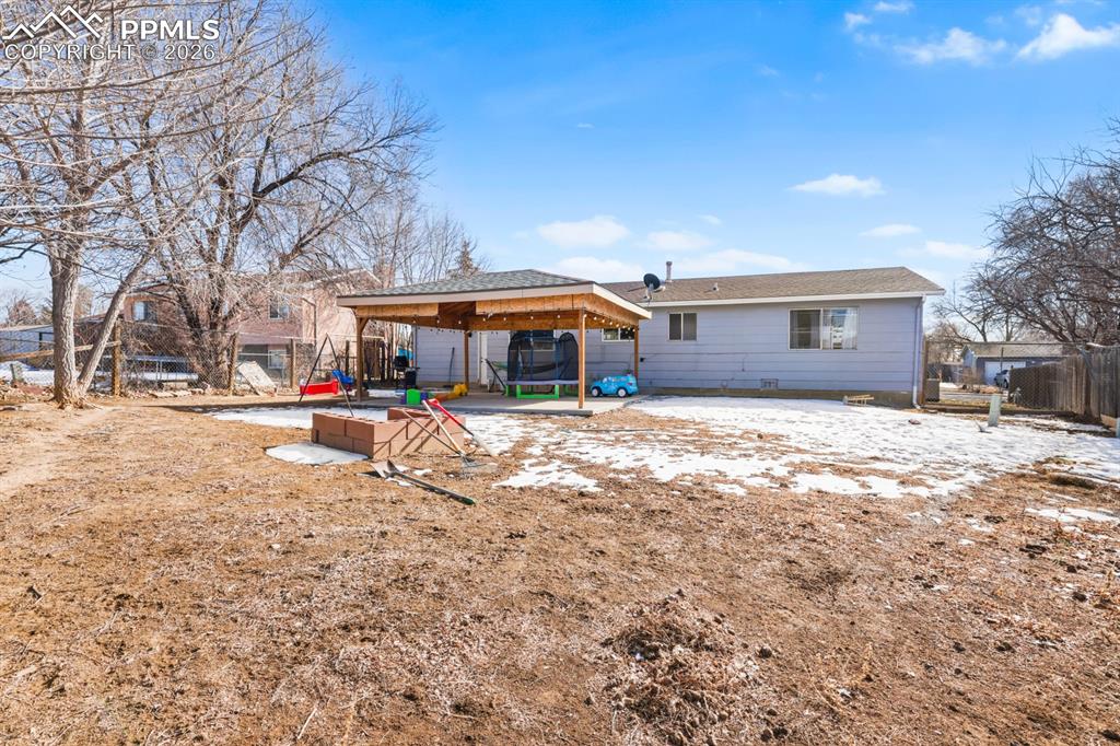 Image 35 of 37: Snow covered back of property with a gazebo and a patio