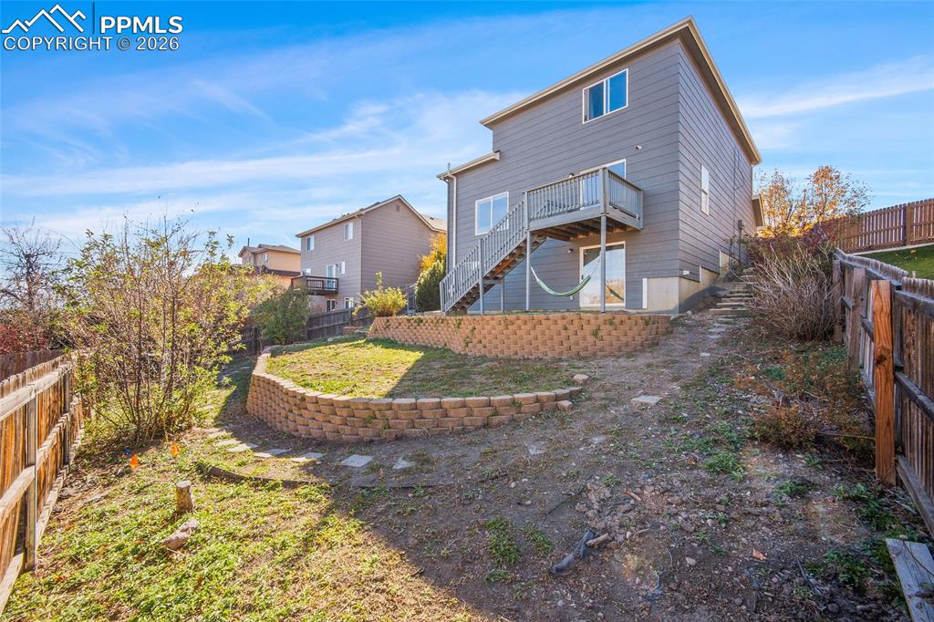 Image 28 of 47: Back of house featuring a fenced backyard and a wooden deck